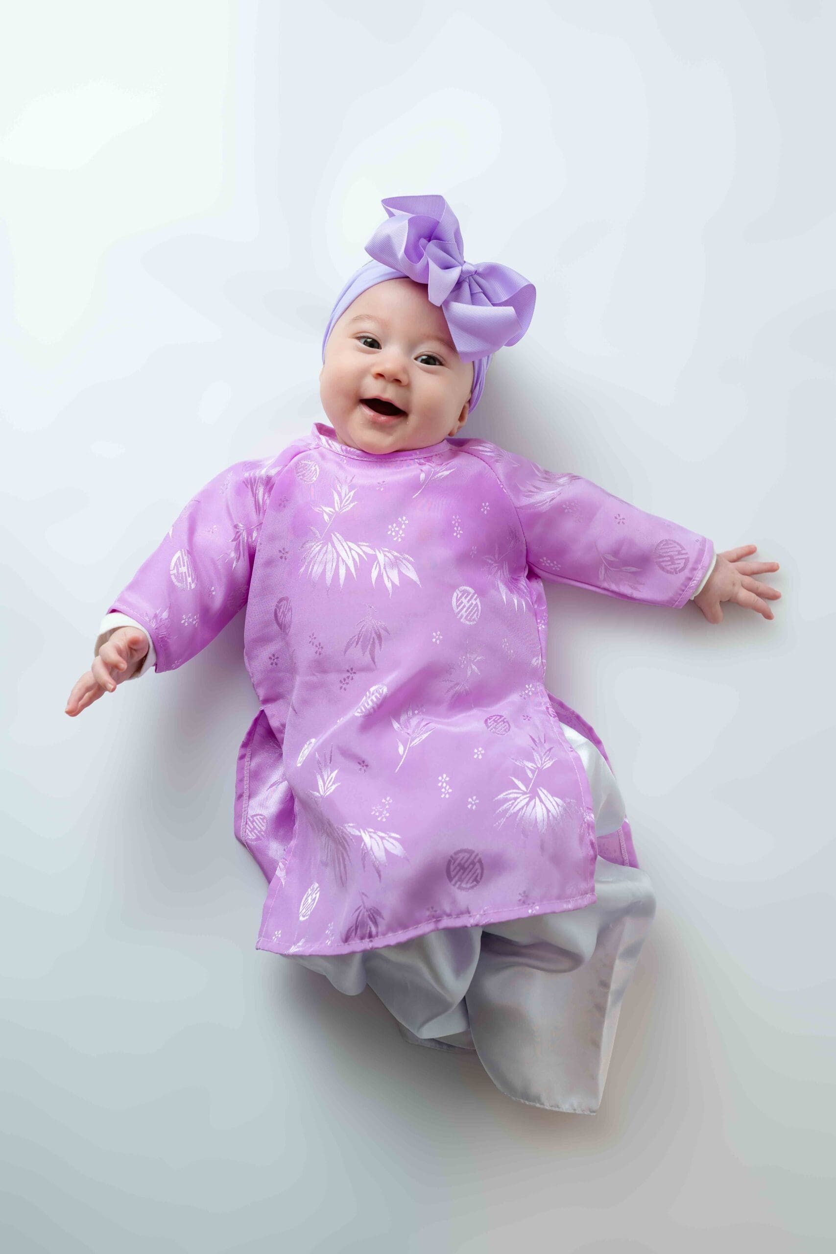 photo of a baby dressed in traditional lunar new year outfit smiling